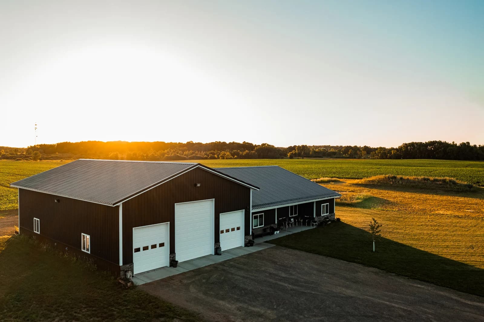 Sherman barndominium with attached garage and covered porch at sunset